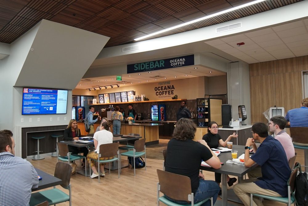 Students sit at tables in the Commons in front of the Sidebar coffee shop