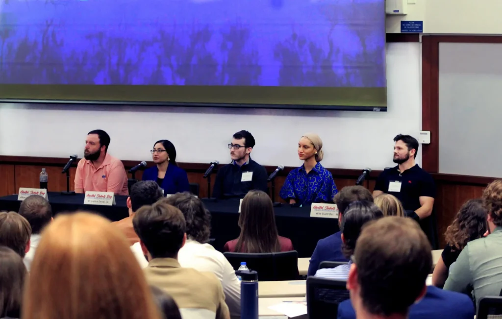 Panelists sit at the front of the event room