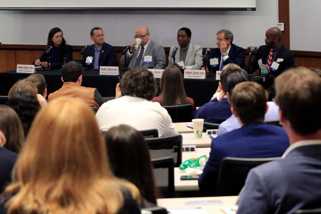 Six panelists at the front of the room