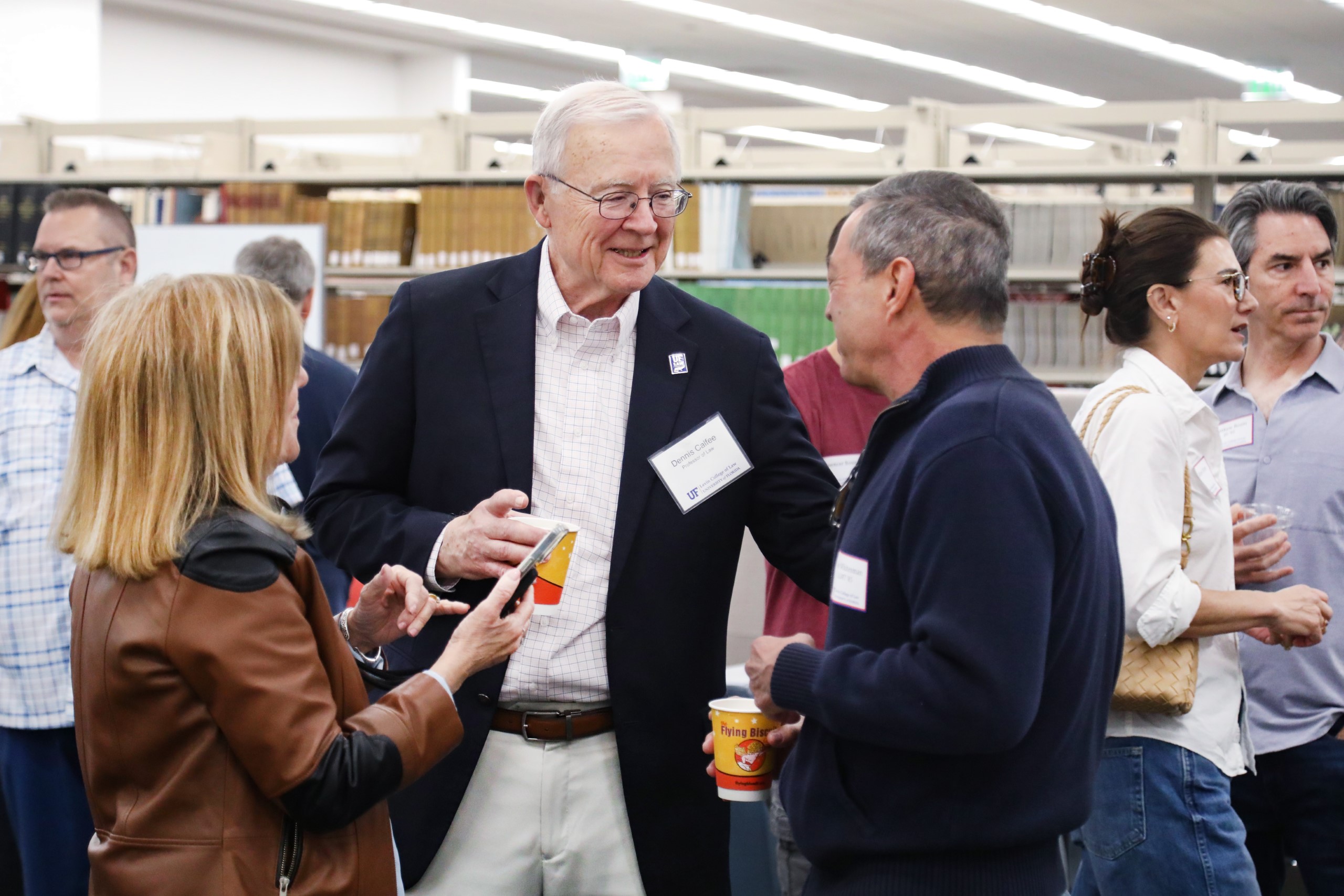 Professor Dennis Calfee talks with guests at a celebratory brunch hosted at UF Law in honor of his 50 years of service to the law school on November 16.