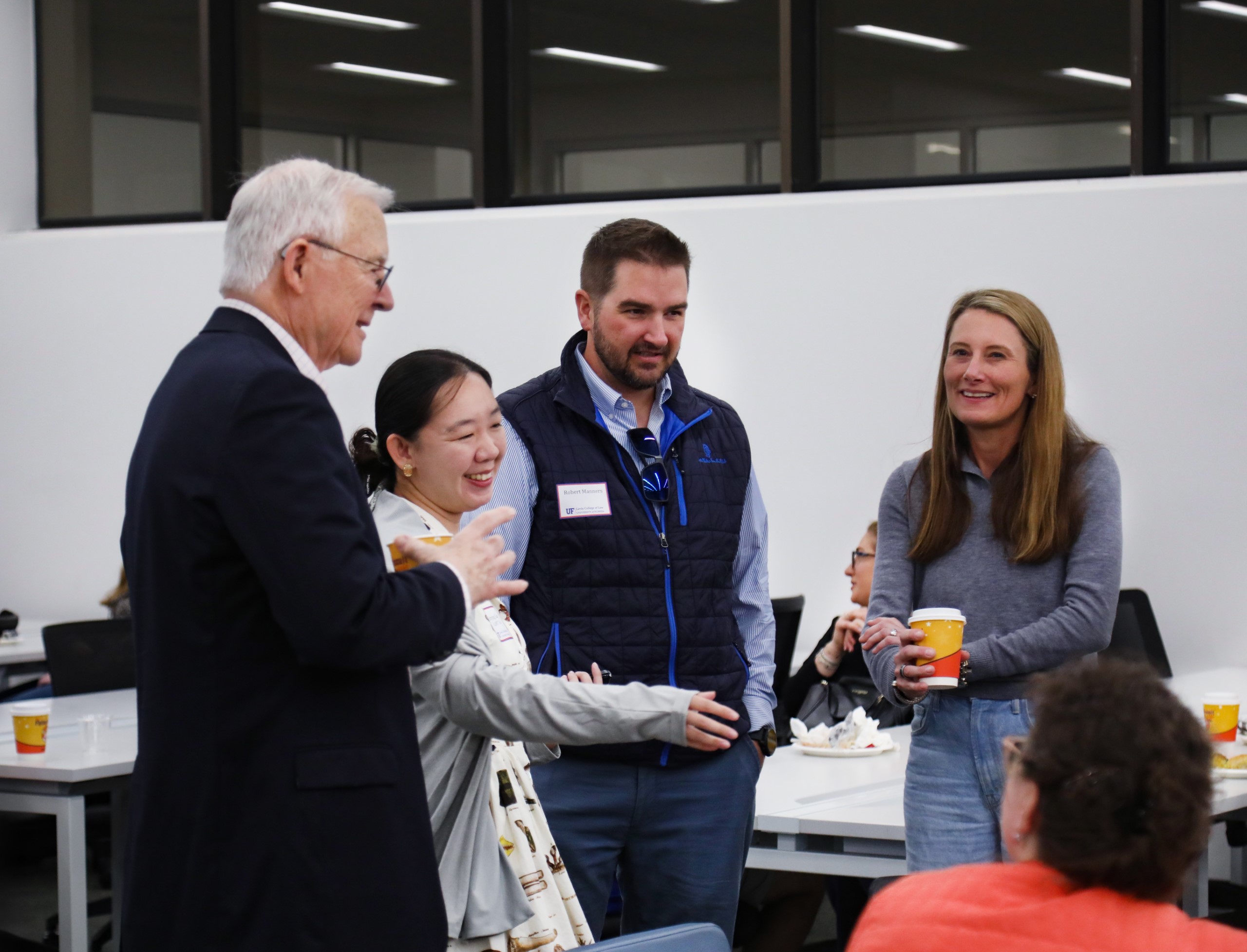 Professor Dennis Calfee talks with guests at a celebratory brunch hosted at UF Law in honor of his 50 years of service to the law school on November 16.