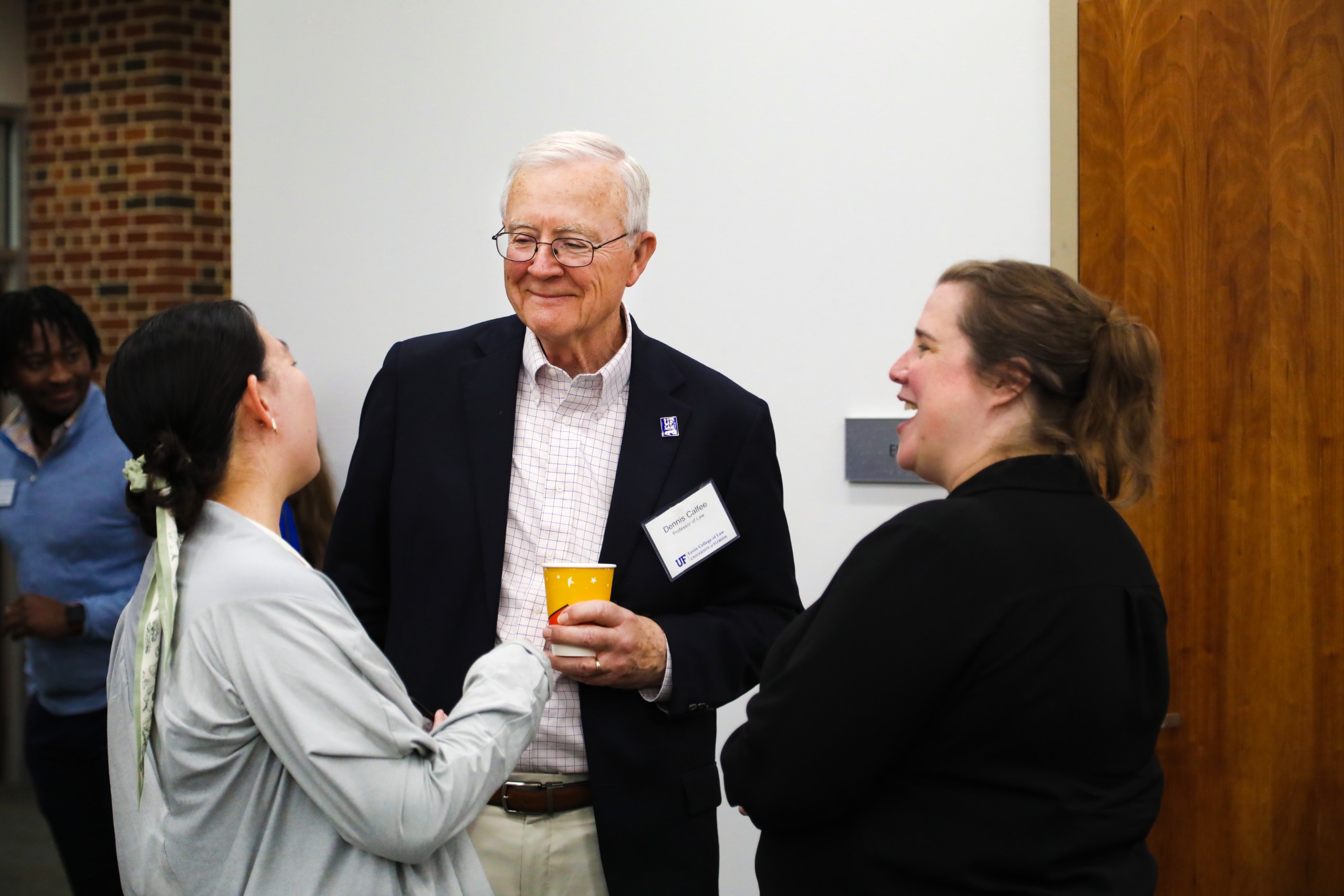 Professor Dennis Calfee and Dean Merritt McAlister chat with a UF Law student at a celebratory brunch hosted at UF Law in honor of Professor Calfee and his 50 years of service to the law school on November 16.