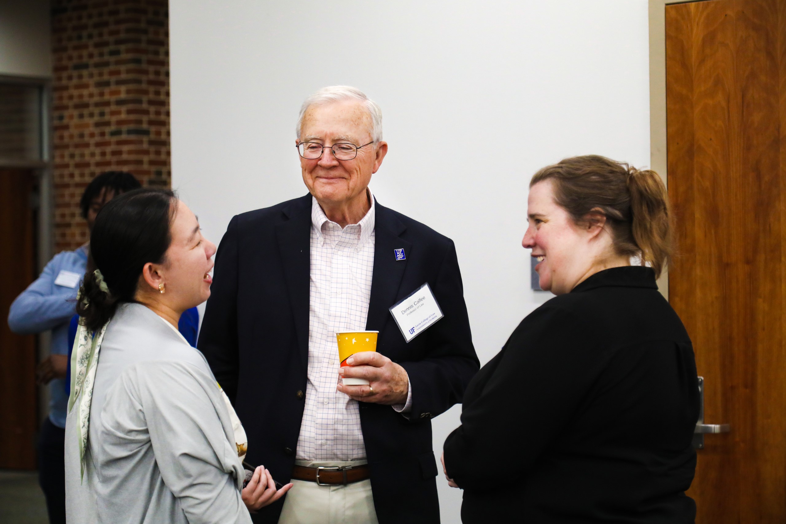 Professor Dennis Calfee and Dean Merritt McAlister chat with a UF Law student at a celebratory brunch hosted at UF Law in honor of Professor Calfee and his 50 years of service to the law school on November 16.