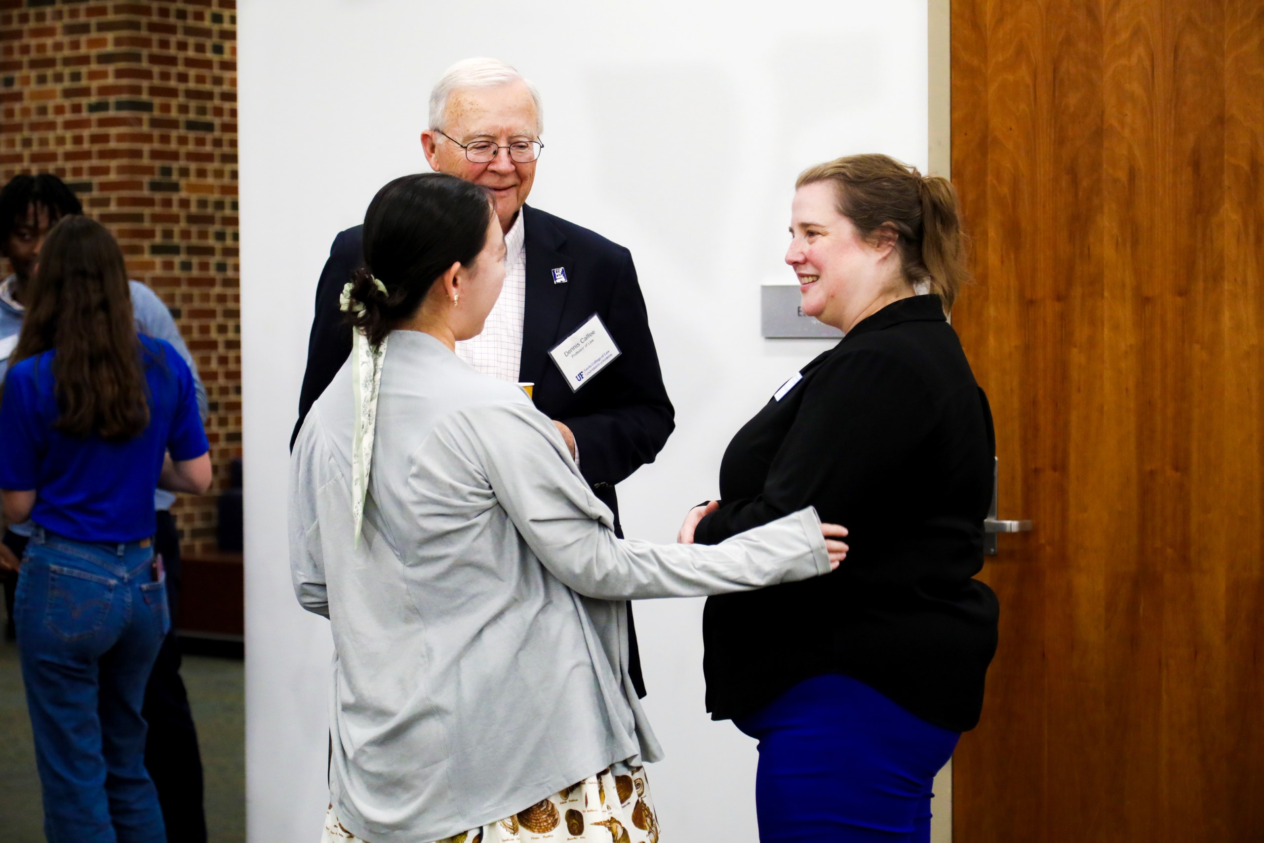 Professor Dennis Calfee and Dean Merritt McAlister chat with a UF Law student at a celebratory brunch hosted at UF Law in honor of Professor Calfee and his 50 years of service to the law school on November 16.
