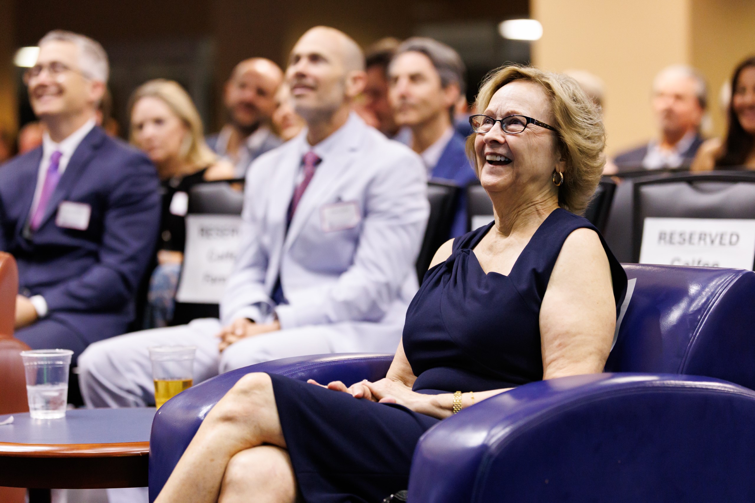 Guests smile as they listen to the speakers at the celebration reception for UF Law's Professor Dennis Calfee and his 50 years of service to the law school. The celebration was held on Friday, November 15 at the University of Florida's Champions Club at Ben Hill Griffin Stadium. The reception included a welcome from Dean Merritt McAlister, and remarks from Masters of Ceremony Judge Robert Luck (JD 04), U.S. Circuit Judge, U.S. Court of Appeals for the 11th Circuit, and Judge Kathryn Kimball Mizelle (JD 12), District Judge, U.S. District Court for the Middle District of Florida. Additional guest speakers reflected on Professor Calfee's 50 year career and the impact that he has had at UF Law and beyond. After recognitions and presentations, Judge Luck and Judge Mizelle made the closing remarks.