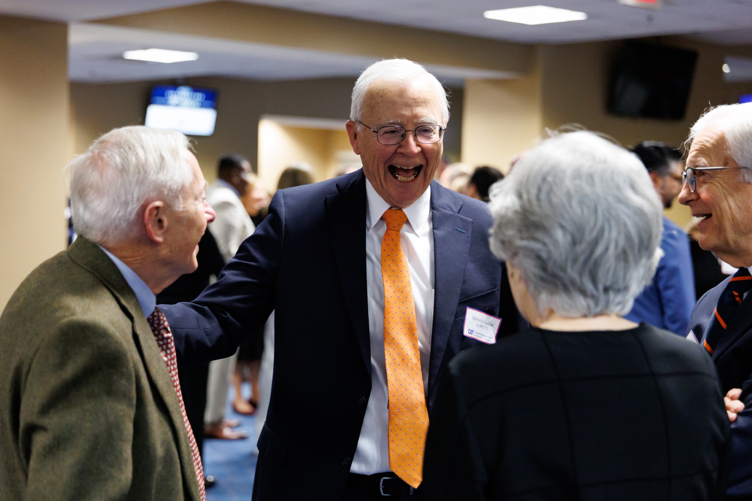 Guests mingle at the celebration reception for UF Law's Professor Dennis Calfee and his 50 years of service to the law school. The celebration was held on Friday, November 15 at the University of Florida's Champions Club at Ben Hill Griffin Stadium. The reception included a welcome from Dean Merritt McAlister, and remarks from Masters of Ceremony Judge Robert Luck (JD 04), U.S. Circuit Judge, U.S. Court of Appeals for the 11th Circuit, and Judge Kathryn Kimball Mizelle (JD 12), District Judge, U.S. District Court for the Middle District of Florida. Additional guest speakers reflected on Professor Calfee's 50 year career and the impact that he has had at UF Law and beyond. After recognitions and presentations, Judge Luck and Judge Mizelle made the closing remarks.