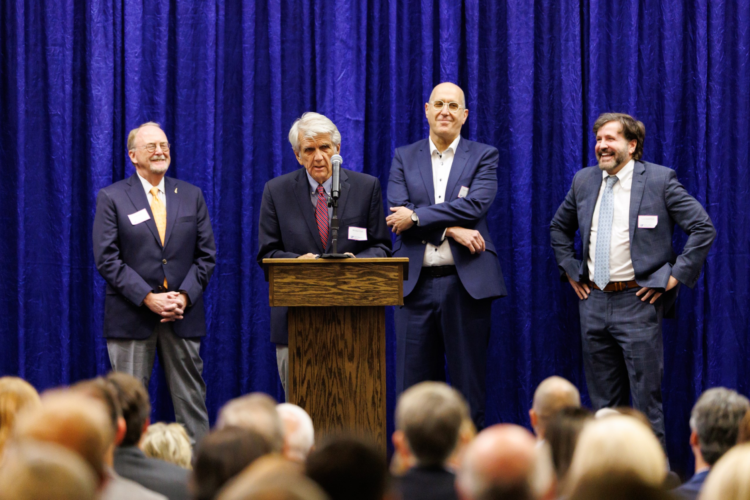 Guest speakers address the audience at the celebration reception for UF Law's Professor Dennis Calfee and his 50 years of service to the law school. The celebration was held on Friday, November 15 at the University of Florida's Champions Club at Ben Hill Griffin Stadium. The reception included a welcome from Dean Merritt McAlister, and remarks from Masters of Ceremony Judge Robert Luck (JD 04), U.S. Circuit Judge, U.S. Court of Appeals for the 11th Circuit, and Judge Kathryn Kimball Mizelle (JD 12), District Judge, U.S. District Court for the Middle District of Florida. Additional guest speakers reflected on Professor Calfee's 50 year career and the impact that he has had at UF Law and beyond. After recognitions and presentations, Judge Luck and Judge Mizelle made the closing remarks.