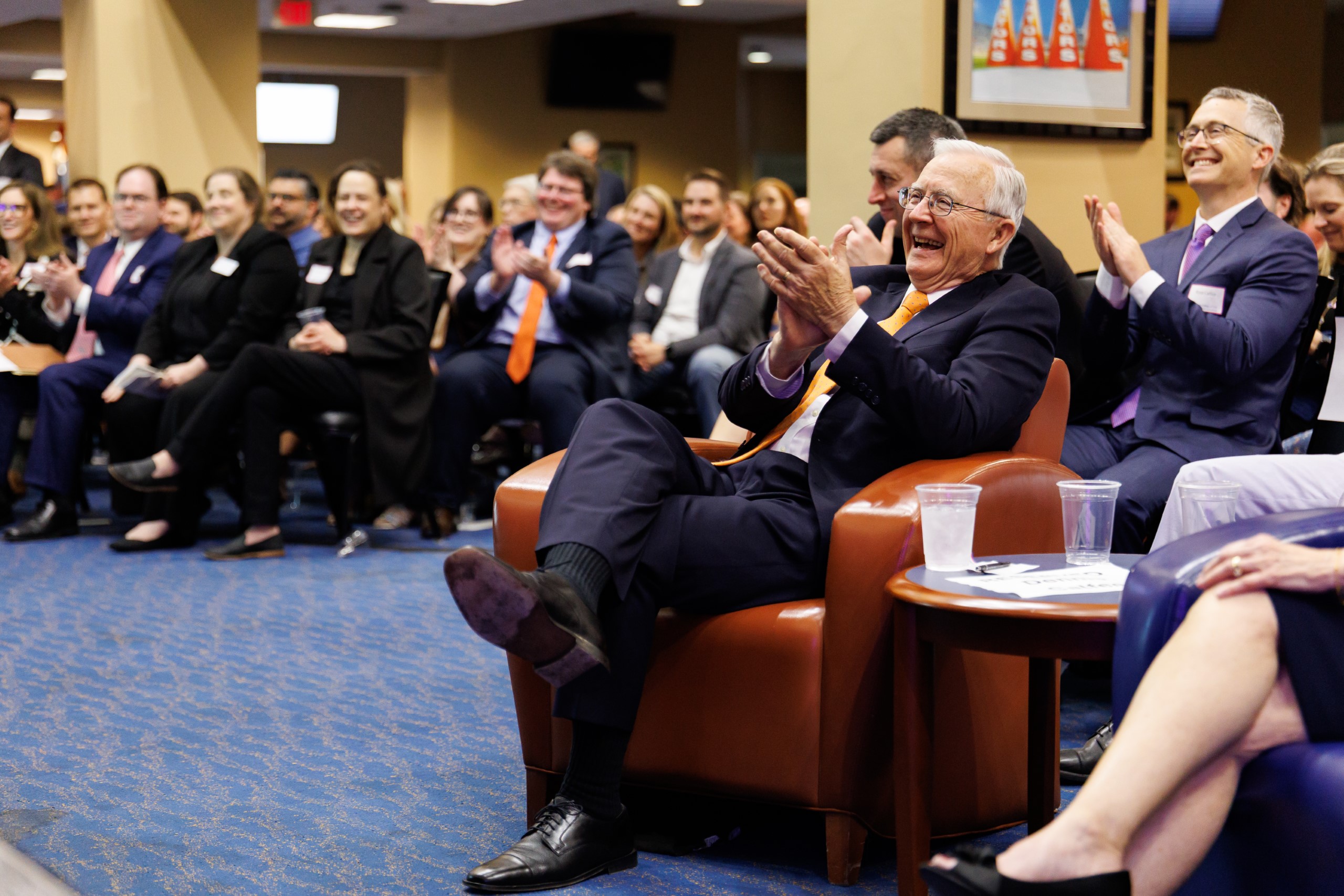 UF Law Professor Dennis Calfee and guests smile as they listen to the speakers at the celebration reception for UF Law's Professor Dennis Calfee and his 50 years of service to the law school. The celebration was held on Friday, November 15 at the University of Florida's Champions Club at Ben Hill Griffin Stadium. The reception included a welcome from Dean Merritt McAlister, and remarks from Masters of Ceremony Judge Robert Luck (JD 04), U.S. Circuit Judge, U.S. Court of Appeals for the 11th Circuit, and Judge Kathryn Kimball Mizelle (JD 12), District Judge, U.S. District Court for the Middle District of Florida. Additional guest speakers reflected on Professor Calfee's 50 year career and the impact that he has had at UF Law and beyond. After recognitions and presentations, Judge Luck and Judge Mizelle made the closing remarks.