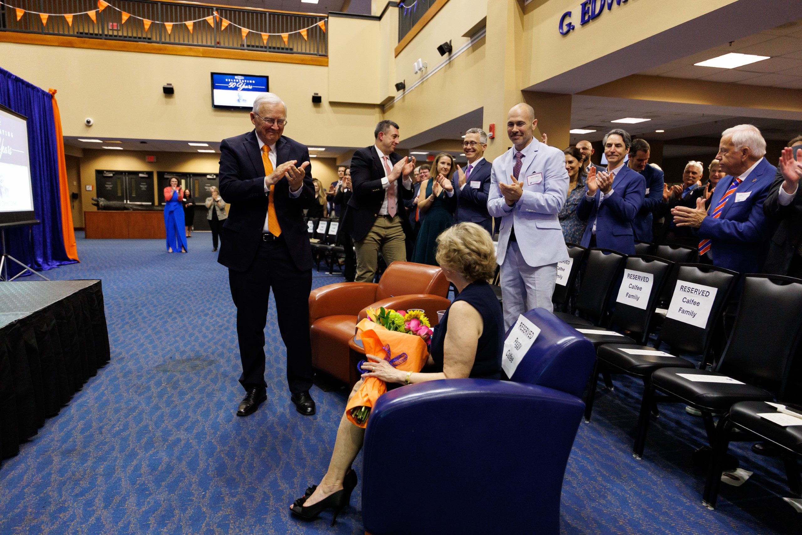 Guests smile as they listen to the speakers at the celebration reception for UF Law's Professor Dennis Calfee and his 50 years of service to the law school. The celebration was held on Friday, November 15 at the University of Florida's Champions Club at Ben Hill Griffin Stadium. The reception included a welcome from Dean Merritt McAlister, and remarks from Masters of Ceremony Judge Robert Luck (JD 04), U.S. Circuit Judge, U.S. Court of Appeals for the 11th Circuit, and Judge Kathryn Kimball Mizelle (JD 12), District Judge, U.S. District Court for the Middle District of Florida. Additional guest speakers reflected on Professor Calfee's 50 year career and the impact that he has had at UF Law and beyond. After recognitions and presentations, Judge Luck and Judge Mizelle made the closing remarks.