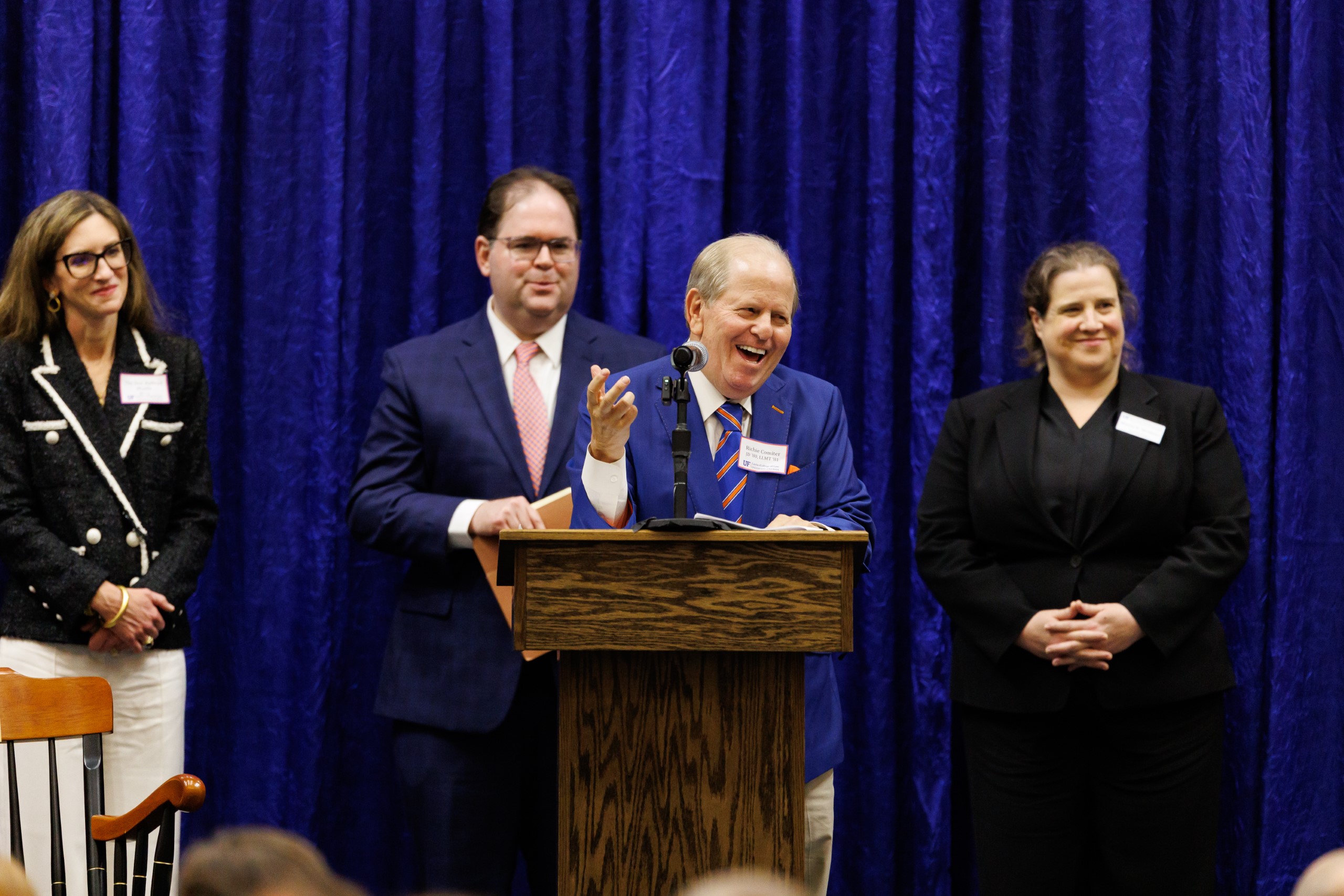 Guest speakers address the audience at the celebration reception for UF Law's Professor Dennis Calfee and his 50 years of service to the law school. The celebration was held on Friday, November 15 at the University of Florida's Champions Club at Ben Hill Griffin Stadium. The reception included a welcome from Dean Merritt McAlister, and remarks from Masters of Ceremony Judge Robert Luck (JD 04), U.S. Circuit Judge, U.S. Court of Appeals for the 11th Circuit, and Judge Kathryn Kimball Mizelle (JD 12), District Judge, U.S. District Court for the Middle District of Florida. Additional guest speakers reflected on Professor Calfee's 50 year career and the impact that he has had at UF Law and beyond. After recognitions and presentations, Judge Luck and Judge Mizelle made the closing remarks.