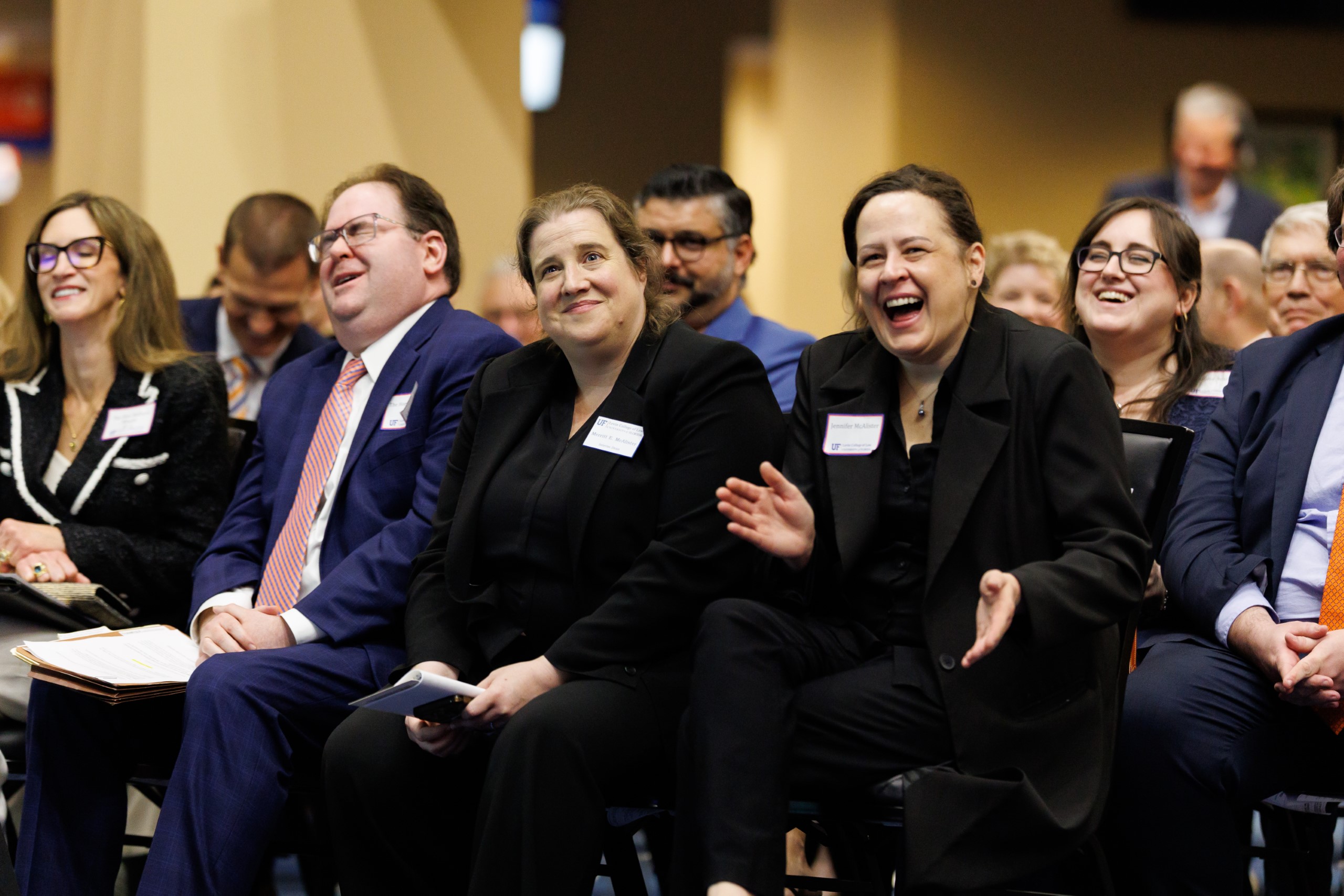 UF Law Dean Merritt McAlister and guests smile as they listen to the speakers at the celebration reception for UF Law's Professor Dennis Calfee and his 50 years of service to the law school. The celebration was held on Friday, November 15 at the University of Florida's Champions Club at Ben Hill Griffin Stadium. The reception included a welcome from Dean Merritt McAlister, and remarks from Masters of Ceremony Judge Robert Luck (JD 04), U.S. Circuit Judge, U.S. Court of Appeals for the 11th Circuit, and Judge Kathryn Kimball Mizelle (JD 12), District Judge, U.S. District Court for the Middle District of Florida. Additional guest speakers reflected on Professor Calfee's 50 year career and the impact that he has had at UF Law and beyond. After recognitions and presentations, Judge Luck and Judge Mizelle made the closing remarks.