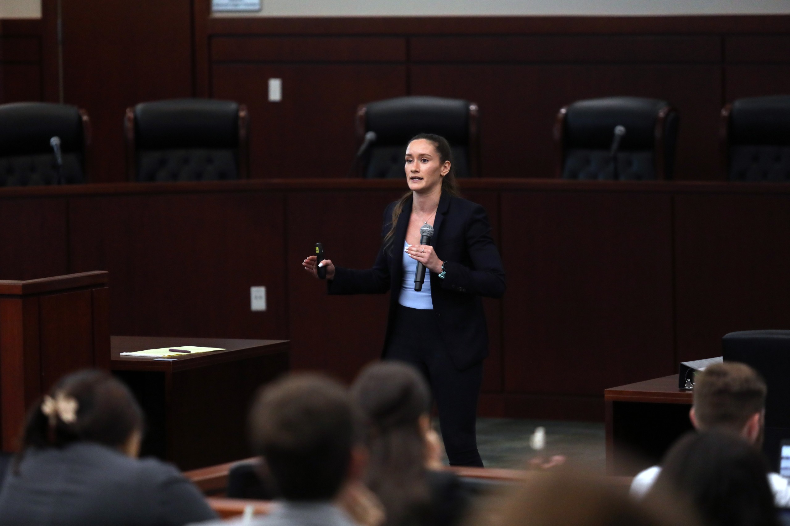 Individual speaking to an audience in a formal setting.